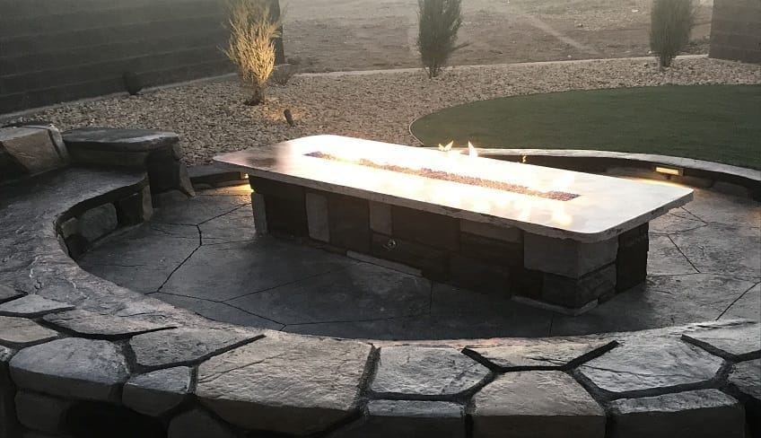 Custom stone fire pit with built-in seating for outdoor entertainment