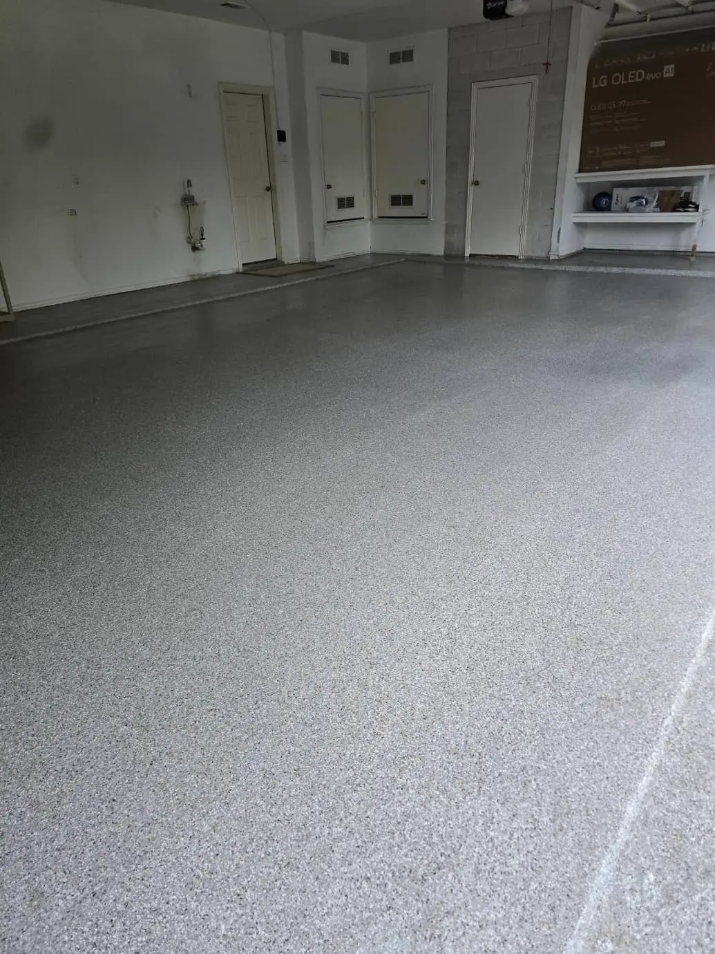 Professional epoxy garage floor with decorative flake system in modern residential space