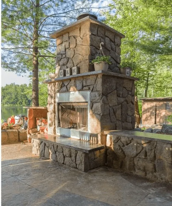 Custom-built stone fireplace in an elegant outdoor living area with seating