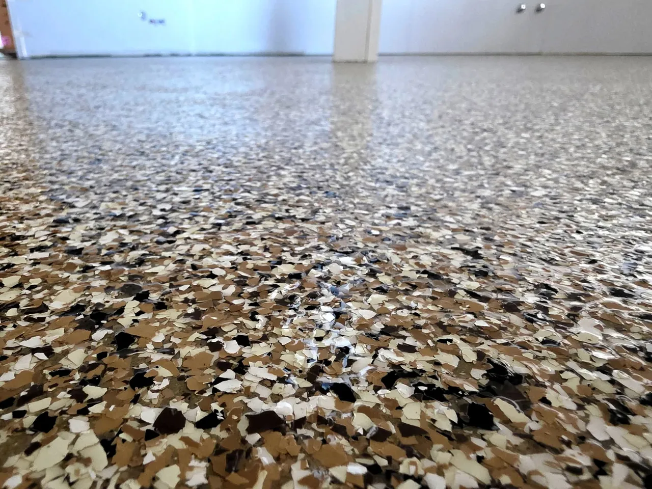 Premium garage floor coating in Frisco with brown tan decorative flake epoxy finish