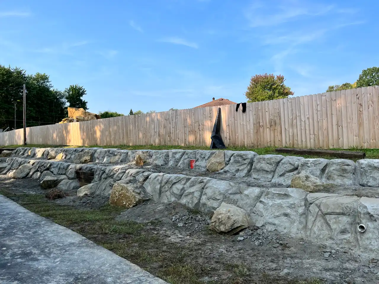Concrete retaining wall with hand-carved stone finish on a Benbrook TX hillside lot