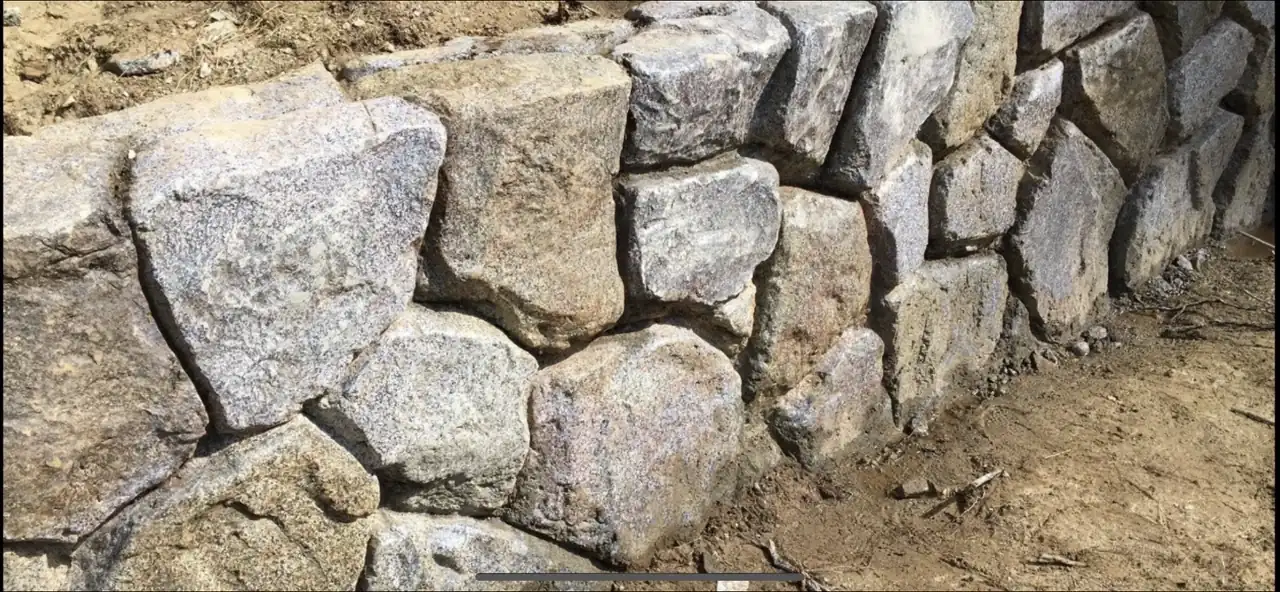 Concrete retaining wall with hand-carved stone finish in Burleson TX