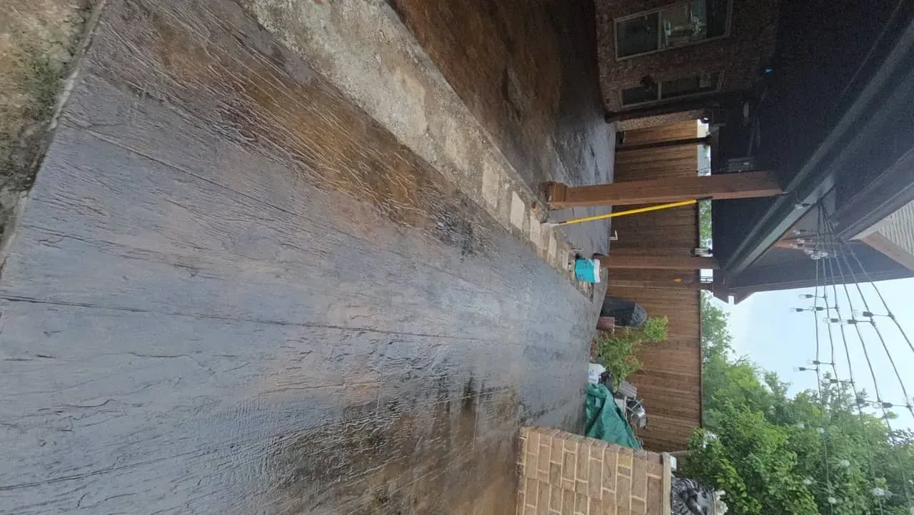 Additional view of the completed stamped concrete overlay patio showcasing the authentic wood grain texture and rich color variation in Southlake, TX