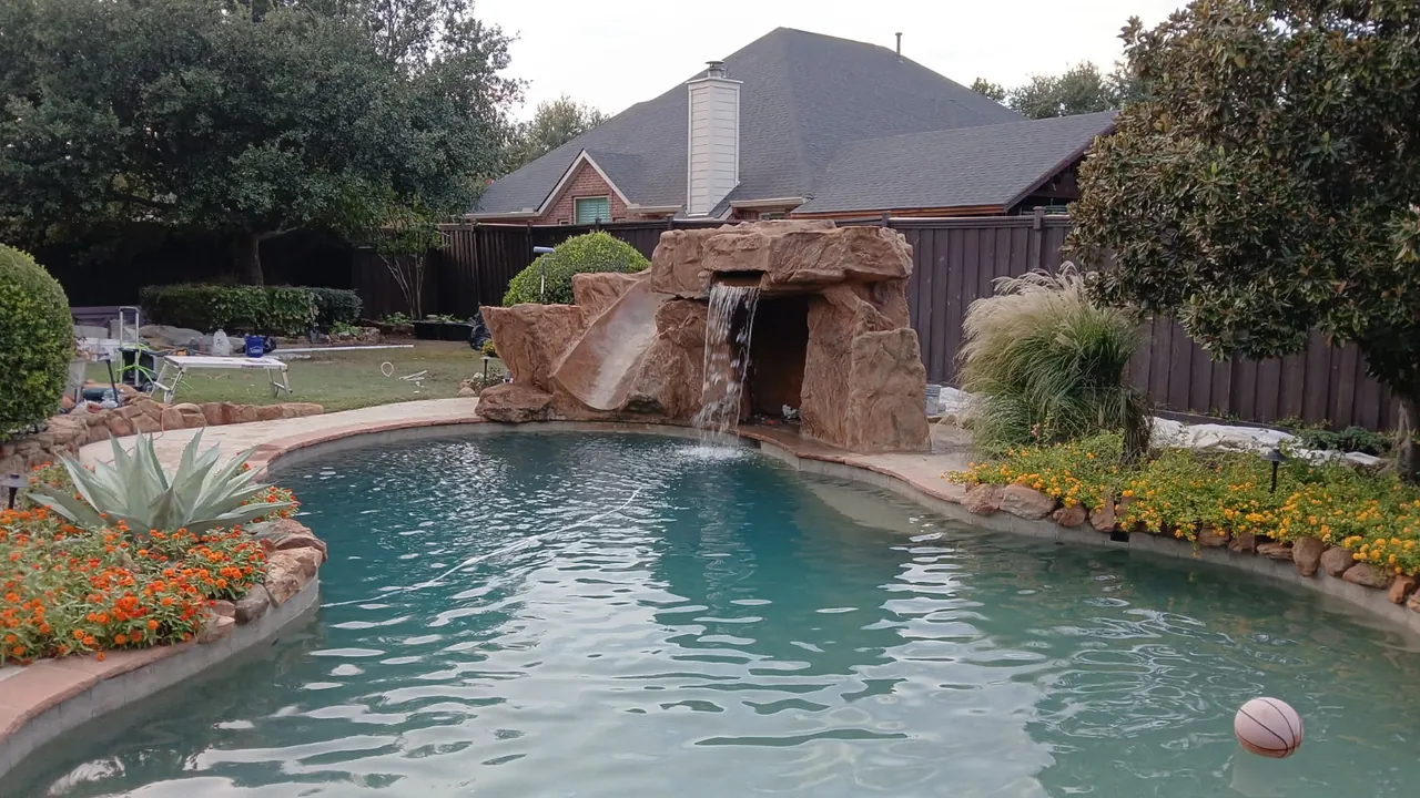 Pool waterfall and grotto slide water feature installation