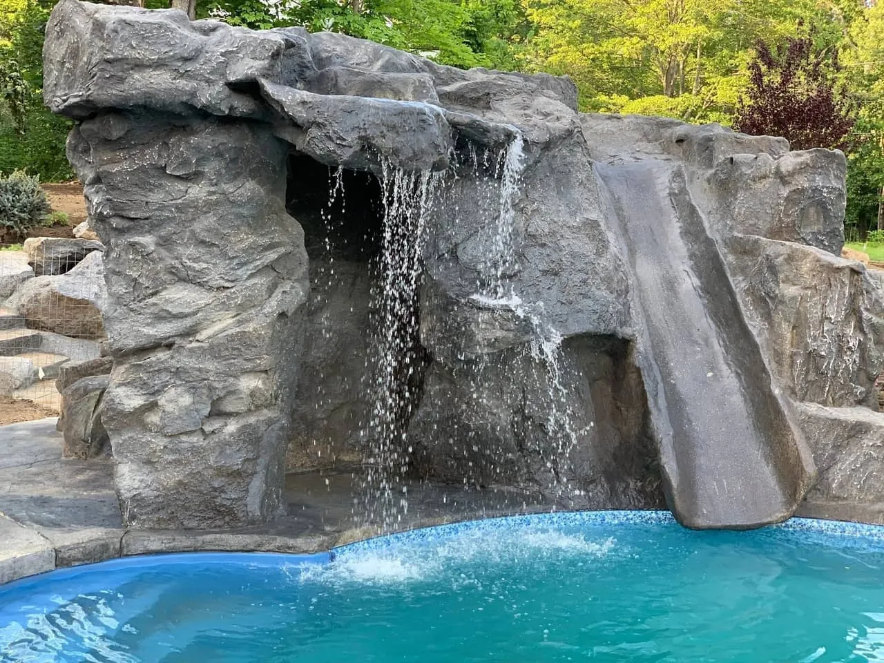 Hand-carved GFRC grotto waterfall with slide on a Frisco-area pool